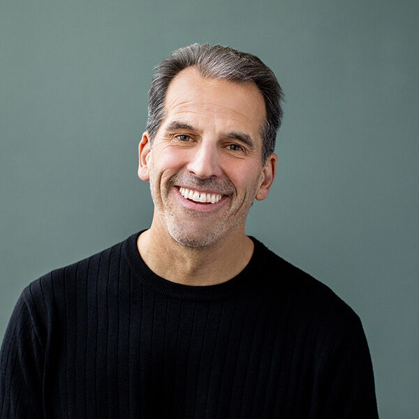 Portrait of Doug Nathan in front of teal backdrop